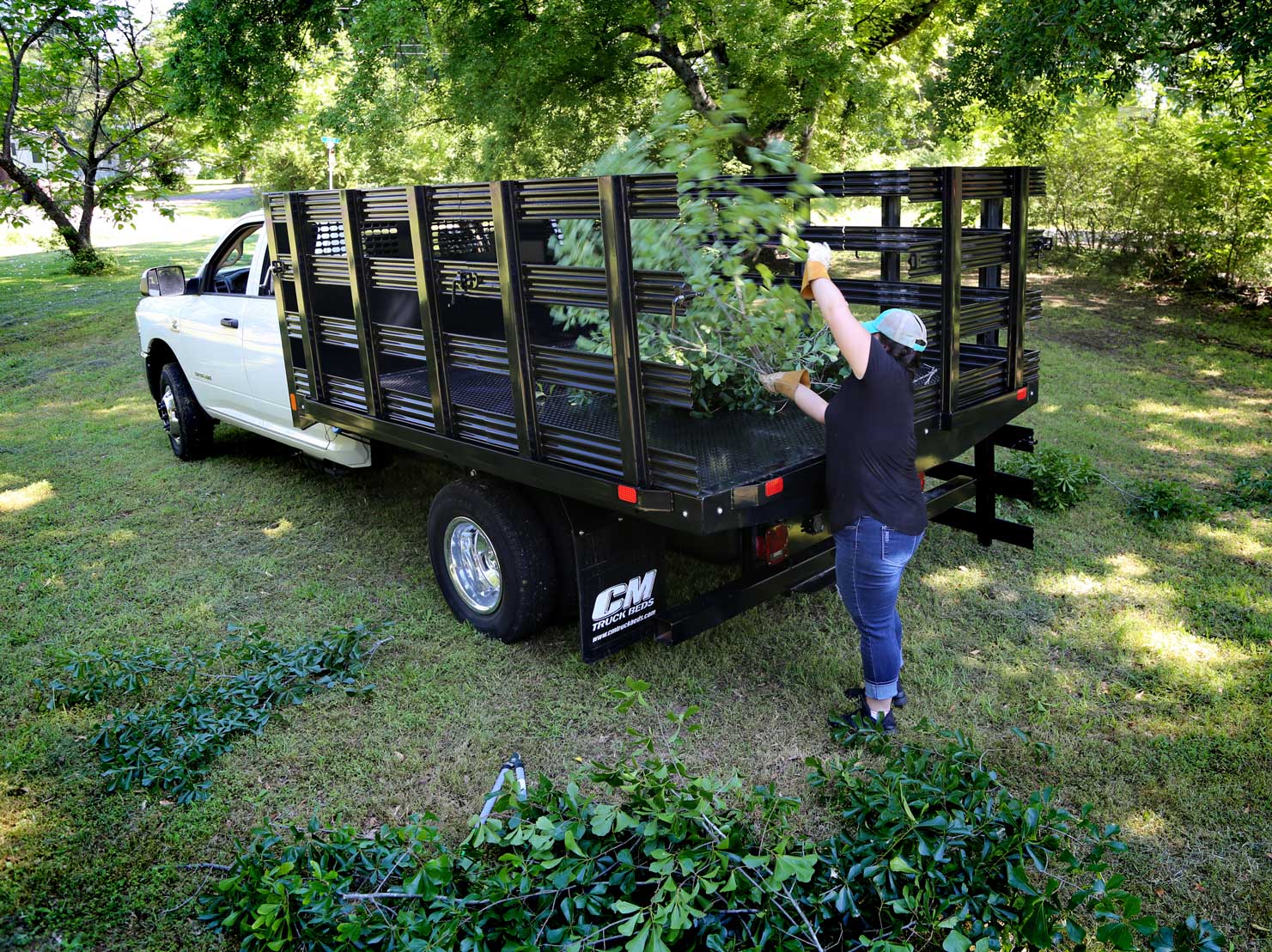 Landscaper using PL trailer bed with stake side option to clean up leaves from lawn